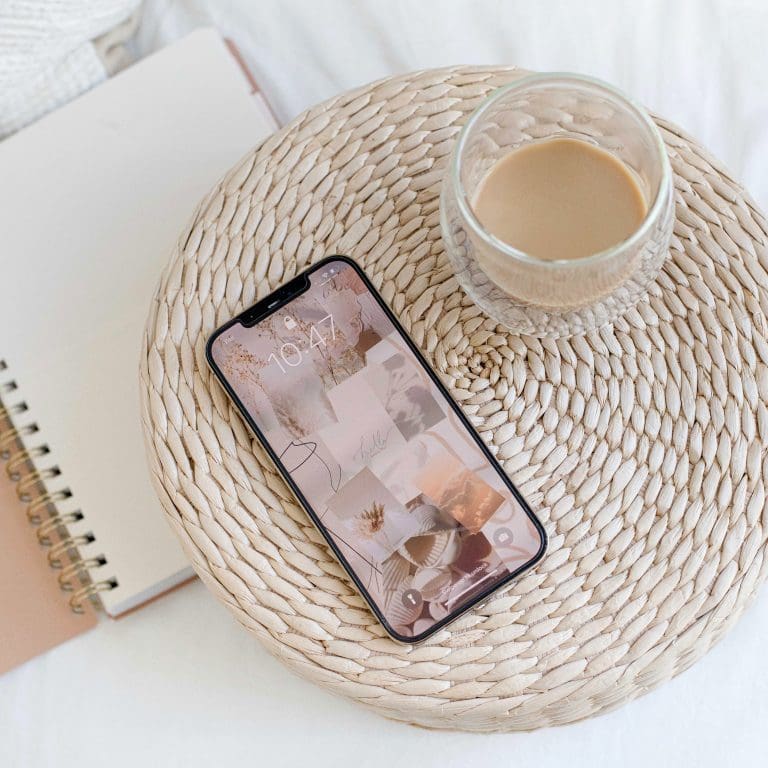 cell phone with tea laying on a mat with a notebook