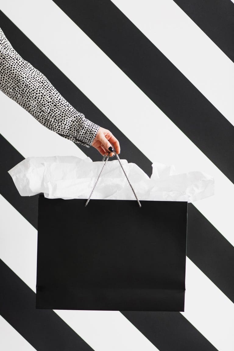 black shopping bag amongst striped background